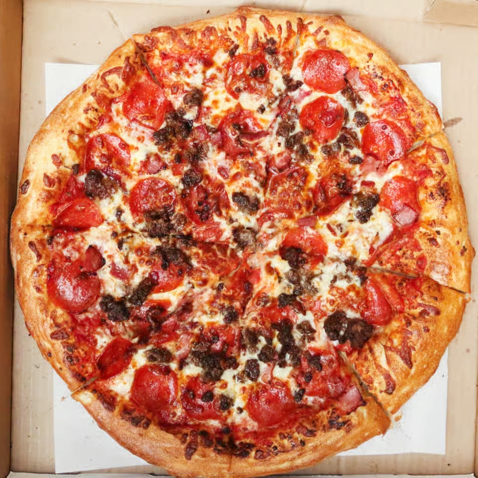 A Mizan Pizza pepperoni and sausage pizza, sliced, in a cardboard delivery box.